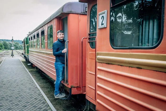 Framed Print : Man stands on the bandwagon of old train of a narrow-gauge railway Framed Print : Man stands on the bandwagon of old train of a narrow-gauge railway