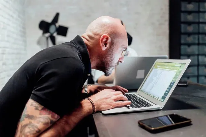 Framed Print : Man using laptop, peering Framed Print : Man using laptop, peering