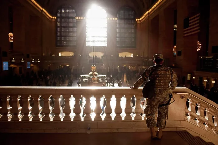 Framed Print : A man wearing a camouflage military uniform looks out over the concourse in Grand Central station Framed Print : A man wearing a camouflage military uniform looks out over the concourse in Grand Central station