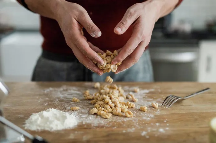 Framed Print : Masculine hands tossing and sprinkling flour on homemade pasta