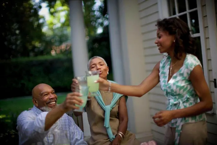 Framed Print : Mature couple sharing a toast with their daughter