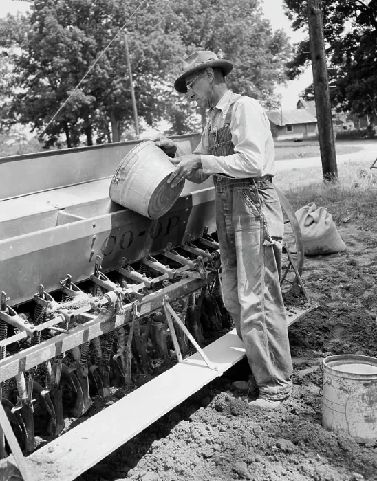 Framed Print : Mature man loading grinds into sowing machine Framed Print : Mature man loading grinds into sowing machine