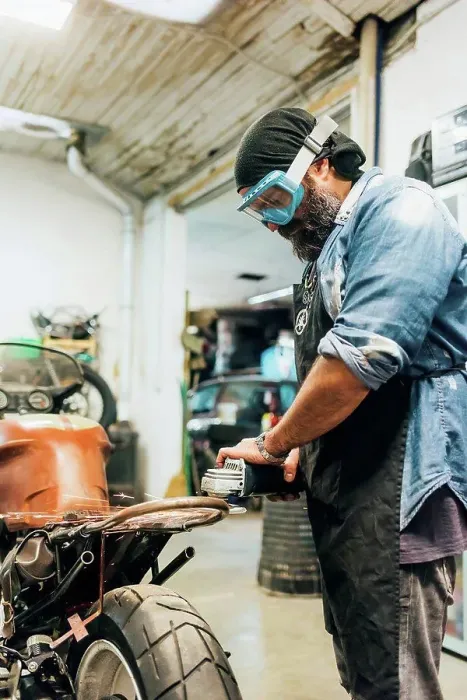 Framed Print : Mature man, working on motorcycle in garage Framed Print : Mature man, working on motorcycle in garage