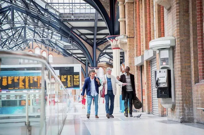 Framed Print : Three mature men at train station, walking together Framed Print : Three mature men at train station, walking together
