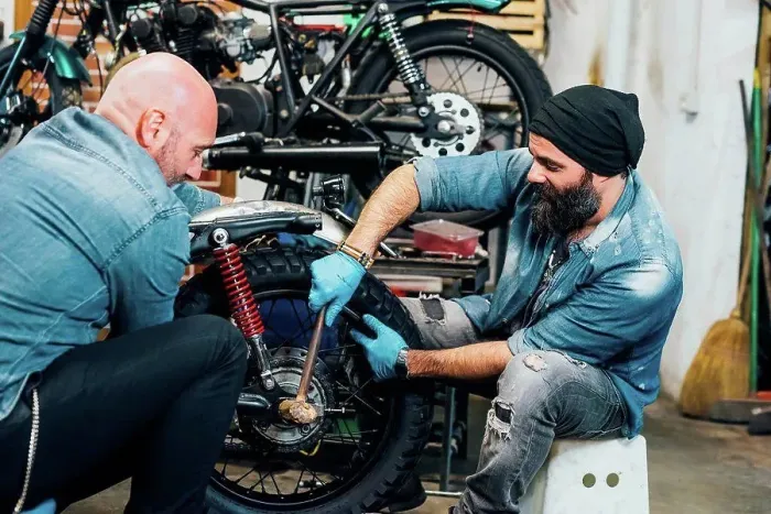 Framed Print : Two mature men, working on motorcycle in garage