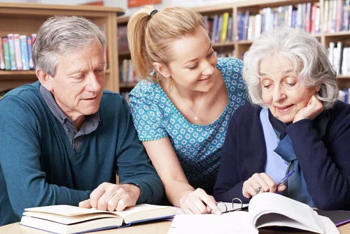 Framed Print : Mature Students Working With Teacher In Library Framed Print : Mature Students Working With Teacher In Library