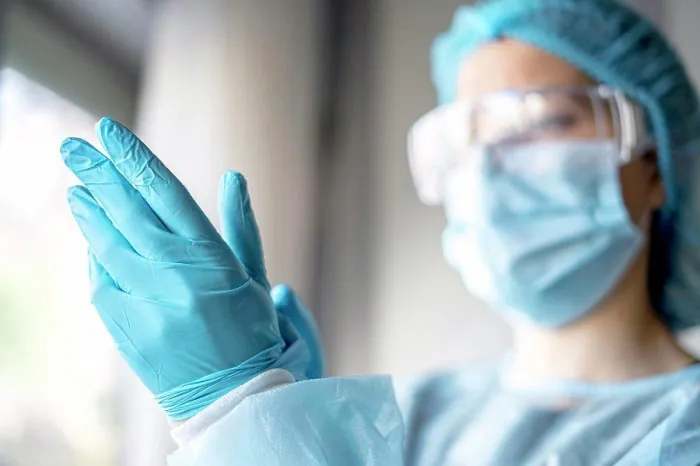 Framed Print : Medicine and Surgery theme: doctor putting on protective blue gloves Framed Print : Medicine and Surgery theme: doctor putting on protective blue gloves