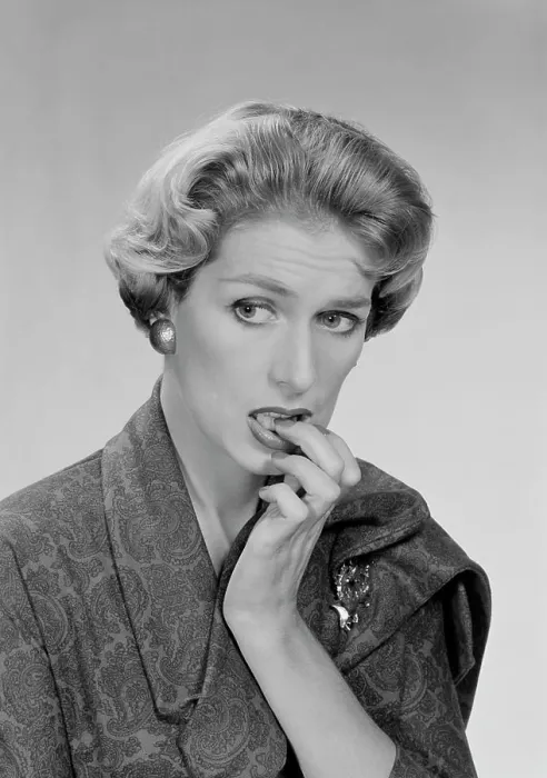 Framed Print : Mid adult woman biting her nails and looking away, studio shot