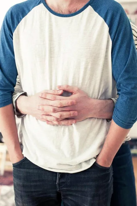 Framed Print : Midsection of gay man embracing partner from behind at home Framed Print : Midsection of gay man embracing partner from behind at home