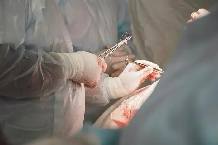 Framed Print : Midsection of medical team performing surgery in operating room