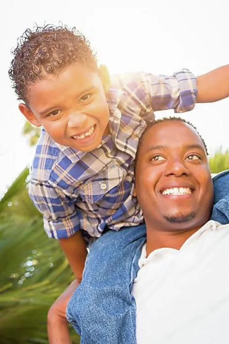 Framed Print : mixed-race son and african american father playing piggyback outdoors together Framed Print : mixed-race son and african american father playing piggyback outdoors together