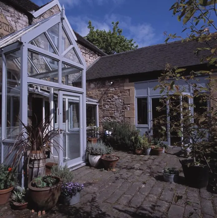 Framed Print : Modern glass porch extension on traditional house with paved courtyard Framed Print : Modern glass porch extension on traditional house with paved courtyard