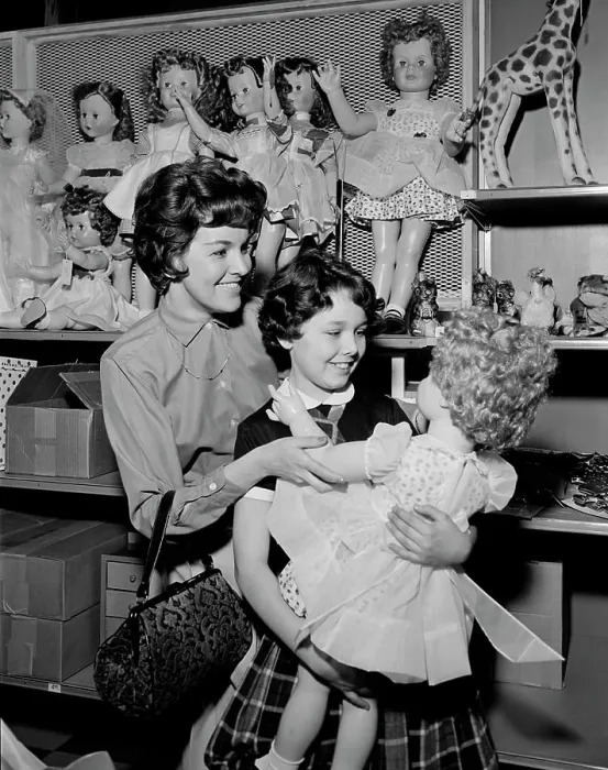 Framed Print : Mother and daughter observing doll in toy shop Framed Print : Mother and daughter observing doll in toy shop