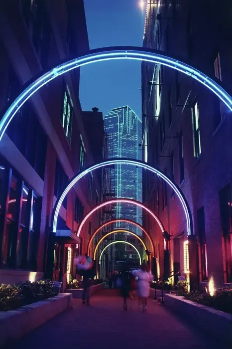 Framed Print : Neon lighted archway in an alley in the West End historical district with Bank of America Building in the background