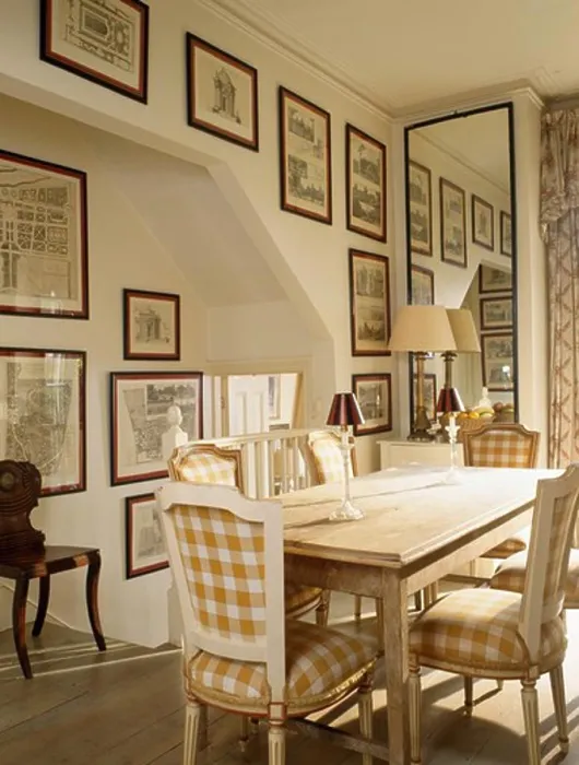 Framed Print : Neutral-checked upholstered chairs and simple wood table in small dining room with tall mirror