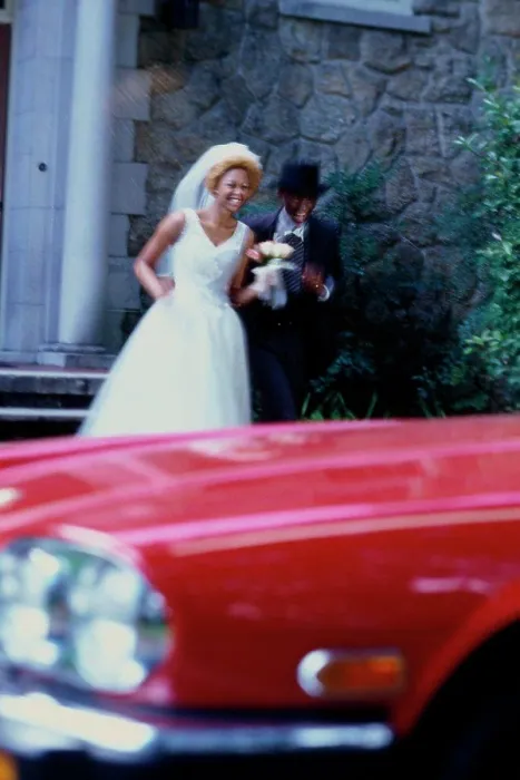 Framed Print : Newlywed couple running towards a car Framed Print : Newlywed couple running towards a car