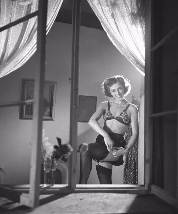 Framed Print : Nylon stockings in the 1940s. A woman is showing how well her nylon stockings fit on her legs