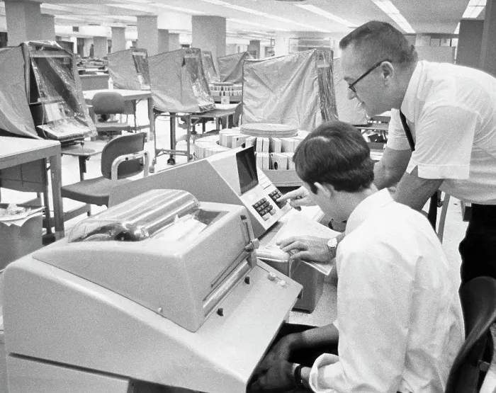 Framed Print : Office worker demonstrates the computer interrogation device for updating customer records Framed Print : Office worker demonstrates the computer interrogation device for updating customer records
