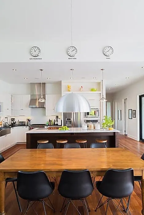 Framed Print : Open-concept dining and kitchen area with antique dining table with black leather and plastic chairs Framed Print : Open-concept dining and kitchen area with antique dining table with black leather and plastic chairs