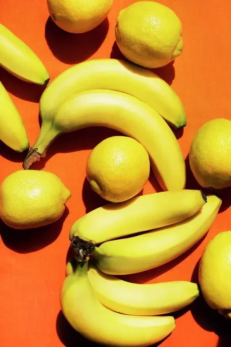 Framed Print : Overhead view of bananas and lemons on orange background Framed Print : Overhead view of bananas and lemons on orange background