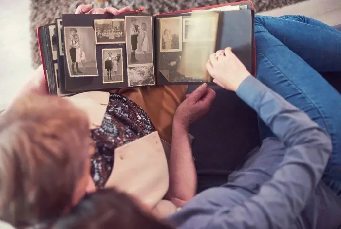Framed Print : Overhead view of young woman on sofa with grandmother looking at photo album Framed Print : Overhead view of young woman on sofa with grandmother looking at photo album