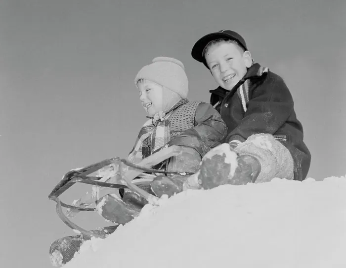 Framed Print : Pair of children sledging in winter scenery