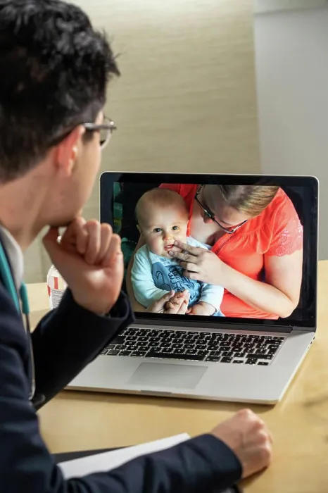 Framed Print : Pediatrician in remote consultation with mother and infant with skin irritation Framed Print : Pediatrician in remote consultation with mother and infant with skin irritation