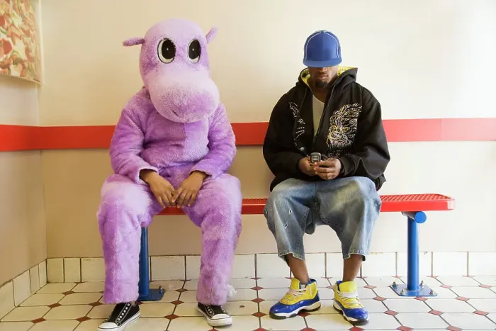 Framed Print : Person in hippo costume sitting next to a man text messaging on a mobile phone Framed Print : Person in hippo costume sitting next to a man text messaging on a mobile phone