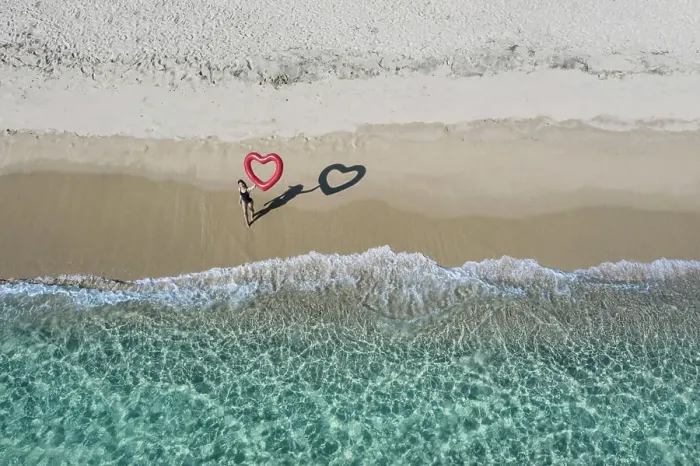 Framed Print : Person standing on the beach drawing a heart in the sand with aerial ocean view Framed Print : Person standing on the beach drawing a heart in the sand with aerial ocean view