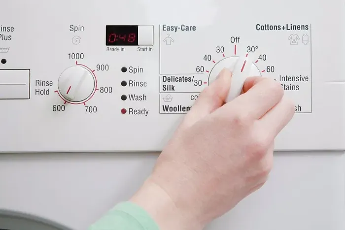 Framed Print : Person turning dial on washing machine Framed Print : Person turning dial on washing machine
