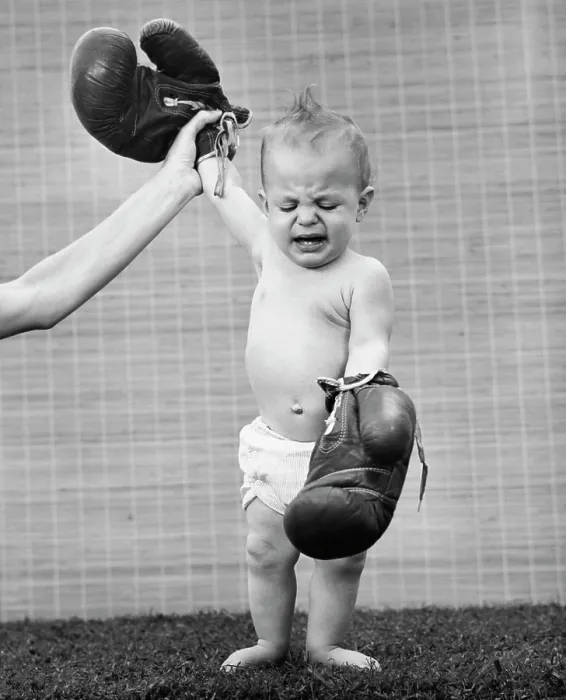 Framed Print : Person's hand raising a baby's hand wearing boxing gloves Framed Print : Person's hand raising a baby's hand wearing boxing gloves