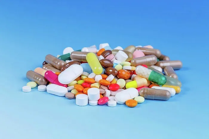 Framed Print : Pile of pills against a blue background Framed Print : Pile of pills against a blue background