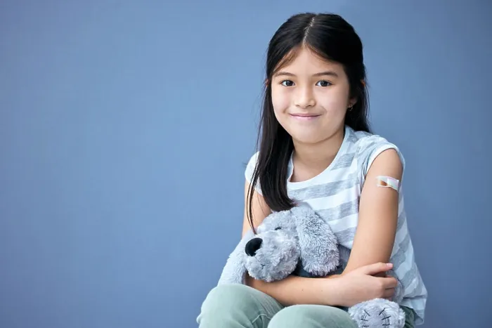 Framed Print : Plaster, portrait and girl child with teddy bear for comfort in studio isolated on blue background
