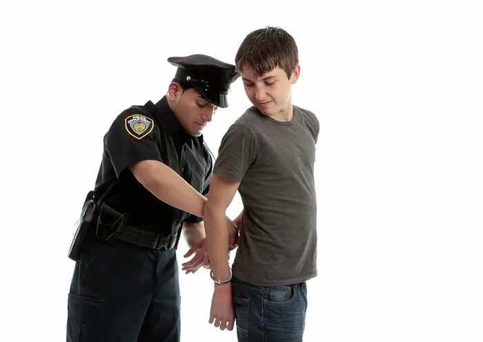 Framed Print : Policeman handcuffing teenager A police officer arrests and handcuffs a young male teen felon Framed Print : Policeman handcuffing teenager A police officer arrests and handcuffs a young male teen felon