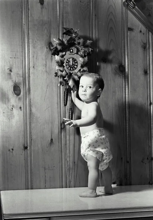 Framed Print : Portrait of a baby boy standing near a cuckoo clock Framed Print : Portrait of a baby boy standing near a cuckoo clock