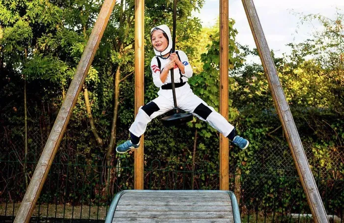 Framed Print : Portrait of boy in astronaut costume riding on playground zip wire