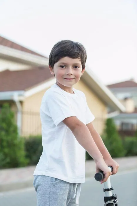 Framed Print : Portrait of boy with push scooter in town