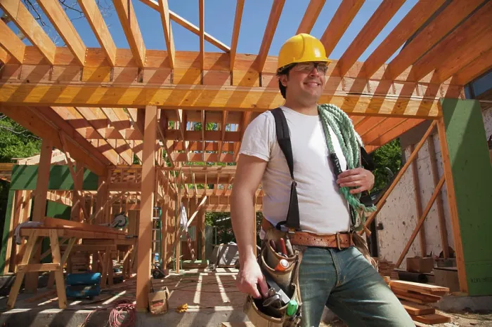 Framed Print : Portrait of a construction worker wearing a hard hat and a tool belt while standing on the construction site Framed Print : Portrait of a construction worker wearing a hard hat and a tool belt while standing on the construction site