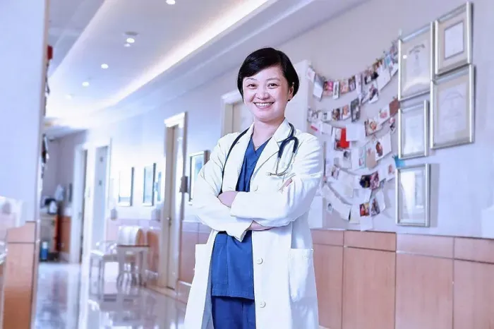 Framed Print : Portrait of doctor in hospital corridor looking at camera smiling