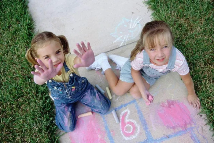 Framed Print : Portrait of two girls drawing on the ground with chalk Framed Print : Portrait of two girls drawing on the ground with chalk