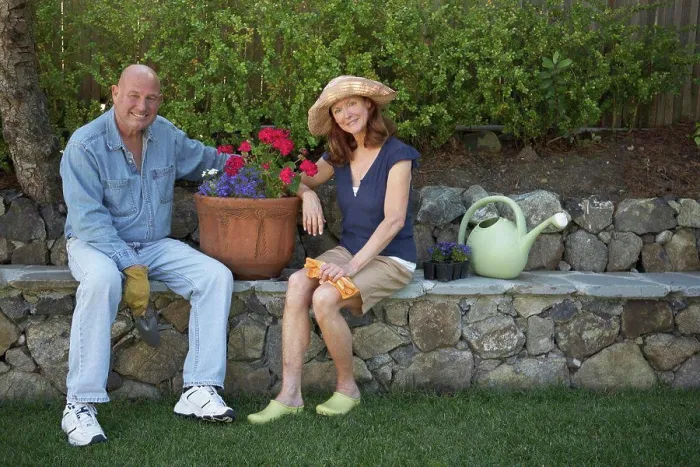Framed Print : Portrait of a mature couple sitting in a garden and smiling