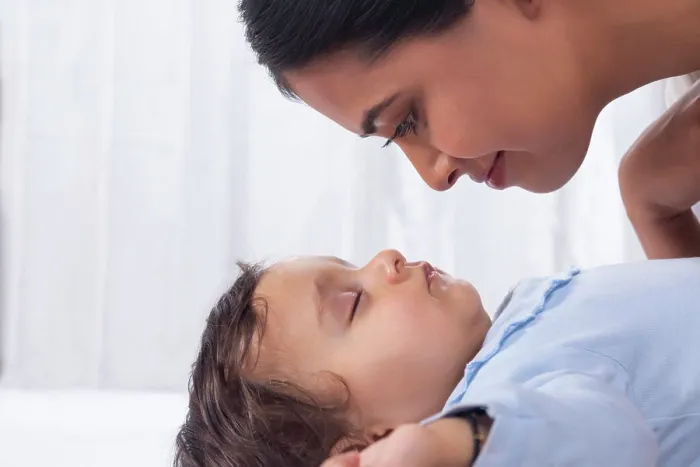 Framed Print : Portrait of mother looking at sleeping baby with affection