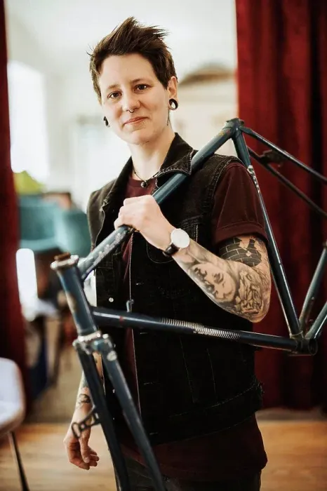 Framed Print : Portrait of pierced and tattooed woman with bicycle frame on her shoulder Framed Print : Portrait of pierced and tattooed woman with bicycle frame on her shoulder