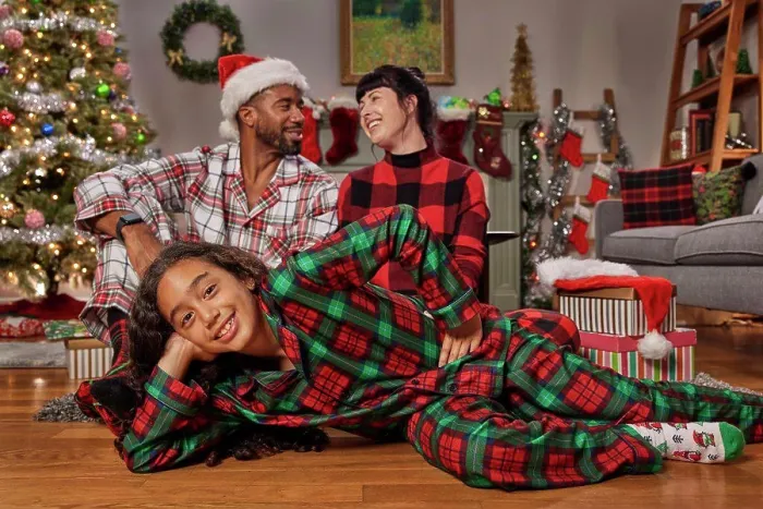 Framed Print : Portrait of a young African American girl laying on the floor looking into camera with her parents in the background