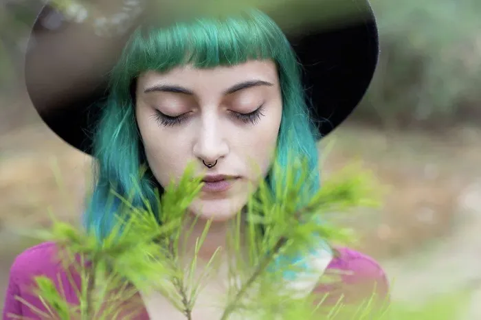Framed Print : Portrait of young woman with dyed blue and green hair and nose piercing in nature