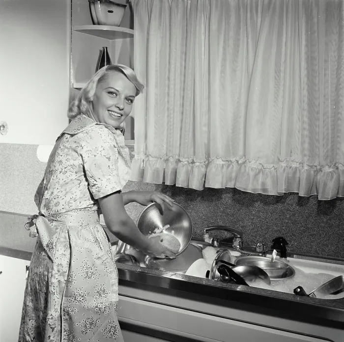 Framed Print : Portrait of a young woman washing pots and pans in a kitchen Framed Print : Portrait of a young woman washing pots and pans in a kitchen