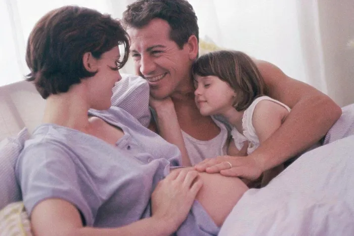 Framed Print : Pregnant woman with her husband and her daughter