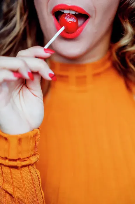 Framed Print : Pretty woman red lips eating a candy