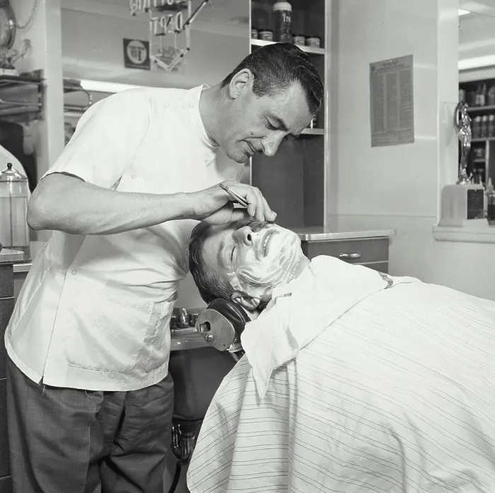 Framed Print : Side profile of a barber shaving a mid adult man in a barbershop Framed Print : Side profile of a barber shaving a mid adult man in a barbershop