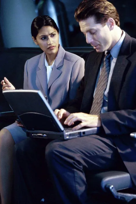 Framed Print : Side profile of a businessman and businesswoman sitting in front of a laptop